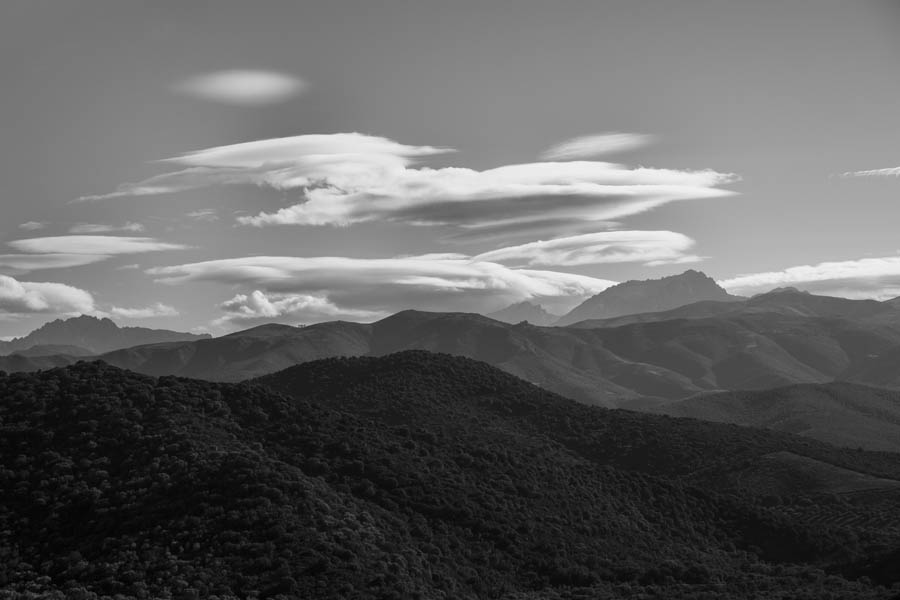 Dieses eindrucksvolle Schwarzweißbild zeigt sanfte Hügel und Berge unter einem mit geschichteten Wolken behangenen Himmel und erinnert an ein kommerzielles Meisterwerk, das in einem professionellen Fotostudio geschaffen wurde.